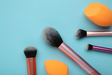 Wall Mural - Makeup buffer brush and beauty makeup sponges on blue background. Beauty and makeup concept