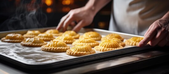 Chef s hands fill a small pie Raw baked goods rest on a metal baking sheet in a bakery Pie and flour products made copy space image