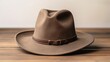 A Stylish Brown Hat Resting on a Rustic Wooden Table
