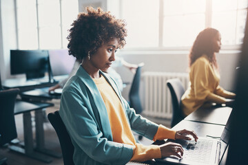 Businesswoman and colleagues working on computers in a bright office