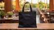 Realistic Black Tote Canvas Fabric Bag Set-up In A Restaurant, Coffee Shop Interior, Tote Mock Up Blank. Black Tote Bag Template. Blurred Effect In Background