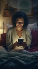 Canvas Print - A woman sitting on a bed looking at her cell phone