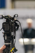 © Microgen - TV camera records a compelling male speaker on stage, delivering impactful insights on fair