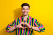 Photo of young cheerful thankful guy showing appreciation heart symbol at chest support lgbt pride isolated on yellow color background