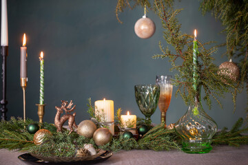 Wall Mural - green and golden christmas decor on table on dark background