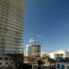 Wall Mural - New construction site of developing residense in american urban area. Industrial tower lifting cranes in Miami, Florida. Concept of housing growth in the USA