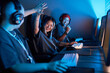 Portrait of Asian young woman playing video games and celebrating victory in blue light