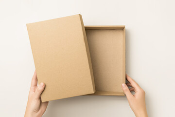 Wall Mural - woman opens empty kraft cardboard box, top view. delivery and packaging concept