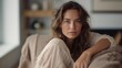 © iuricazac - A peaceful scene of a European woman at home, seated in an armchair, and calmly looking at the camera.