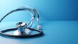  a stethoscope laying on top of a blue surface with a stethoscope on top of it.