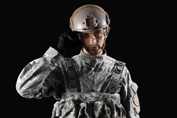 Wall Mural - Young male soldier in helmet on black background