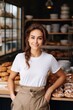 © piai - Young adult woman standing in a family bakery