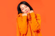 © Pixel-Shot - Young Asian woman in warm clothes on orange background