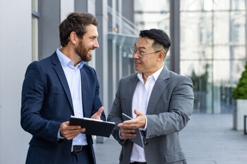 businessmen, a team of men are standing on the street outside the office, talking and discussing wor