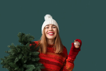 Poster - Beautiful young woman with Christmas tree and ball on green background