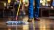 Unrecognizable person cleaning office floor with detailed shot of bright and wide background