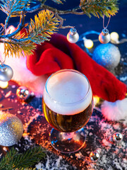 Canvas Print - Beer glass on the table with Christmas lights, Santa Claus hat