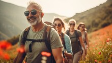 Group Of Middle-aged People Looking At Camera Smiling Spend Free Time Trekking In National Park With Flower Glasses Field, Retired Pensioner Lifestyle Outdoor Activities, Autumn Season, Widow Sunset