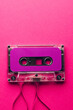 Overhead view of purple cassette tape with copy space on pink background