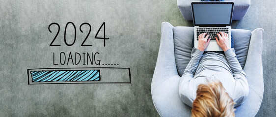 Poster - Loading new year 2024 with man using a laptop in a modern gray chair