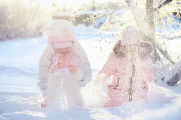 Wall Mural - Family with children play snowy winter games in the park. Winter holidays and family vacation. Winter walk on the street on a sunny frosty day.