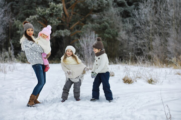 Wall Mural - Happy family playing and laughing in winter outdoors in the snow. City park winter day.