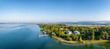 Luftbild-Panorama von der Halbinsel Mettnau im westlichen Bodensee von der Morgensonne angestrahlt mit dem Kurzentrum, Mettnaukur, Schiffanlegestelle und Restaurant Strandcafe