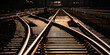 © ON-Photography - Railway track panorama and switches at station in Sauerland Germany with geometrical structure and vanishing point. Warm evening sunlight reflected by bright steel surface, screws and thresholds.