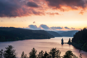 Wall Mural - Lake Vyrnwy, located in mid Wales, an area of outstanding natural beauty, at sunset. The orange sky is reflected in the calm water of the lake