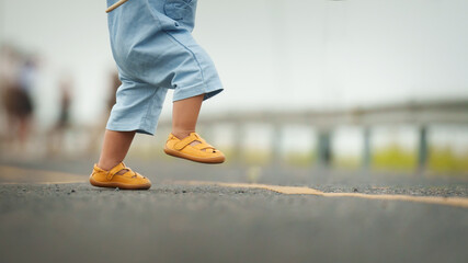 close up leg of infant baby learning to walking first step on pathway