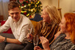 © bernardbodo - Friends sitting at home during christmas drinking Champagne