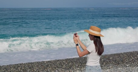 Canvas Print - Woman use cellphone to take photo at the beach