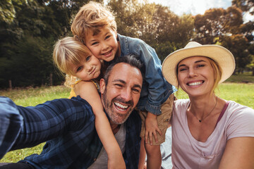 Cheerful family making selfie on picnic