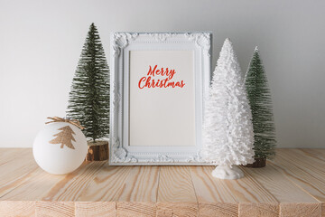 Wall Mural - Holiday concept with Christmas decor and photoframe on wooden table. Creative Christmas or New Year background.