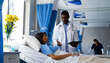 © Wavebreak Media - Diverse male doctor using tablet talking with female patient with iv drip in bed in hospital room