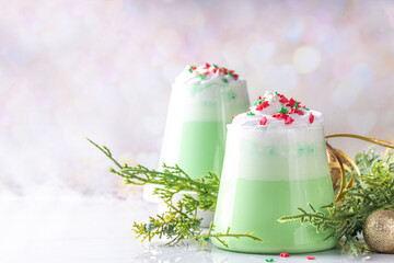 Wall Mural - Green matcha Christmas latte with whipped cream and sugar sprinkles, on xmas New year holiday decorated background