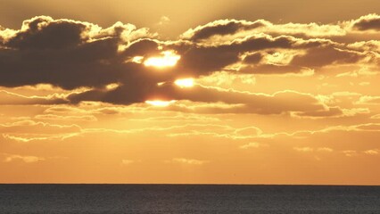 Wall Mural - beautiful evening sunset with big sun and clouds in the atlantic ocean at portugal coast.