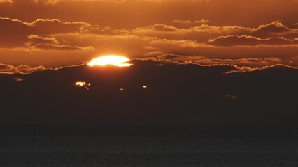 Wall Mural - beautiful evening sunset with big sun and clouds in the atlantic ocean at portugal coast.