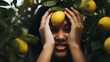 Smiling Woman Holding Fresh Lemon in Front of Her Face Surrounded by Citrus Trees