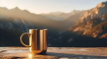 Close Up Of A Gold Mug On A Wooden Table In The Mountains. Blurred Natural Background