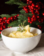 © Arantxa Forcada - Close-up of white bowl with mashed potatoes, on white tablecloth with Christmas decoration, vertical, with copy space