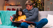 © ihorvsn - Portrait of handsome Caucasian father reading a book of fairytales for his pretty little daughter at decorated home on Christmas night. New Year celebration. Family concept. Magic moments