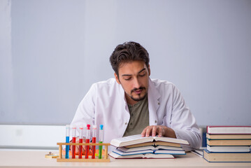 Wall Mural - Young male chemist teacher in front of whiteboard