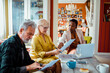 © Marko Geber - Senior couple going over documents with financial advisor at home