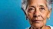 Latin old woman isolated, blue background, displeased expression, face closeup, with copy space for text, logo or design