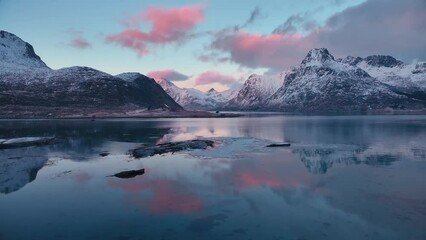 Wall Mural - aerial view of sea, snowy mountains, rorbuer in winter at sunset. lofoten islands, norway. top drone