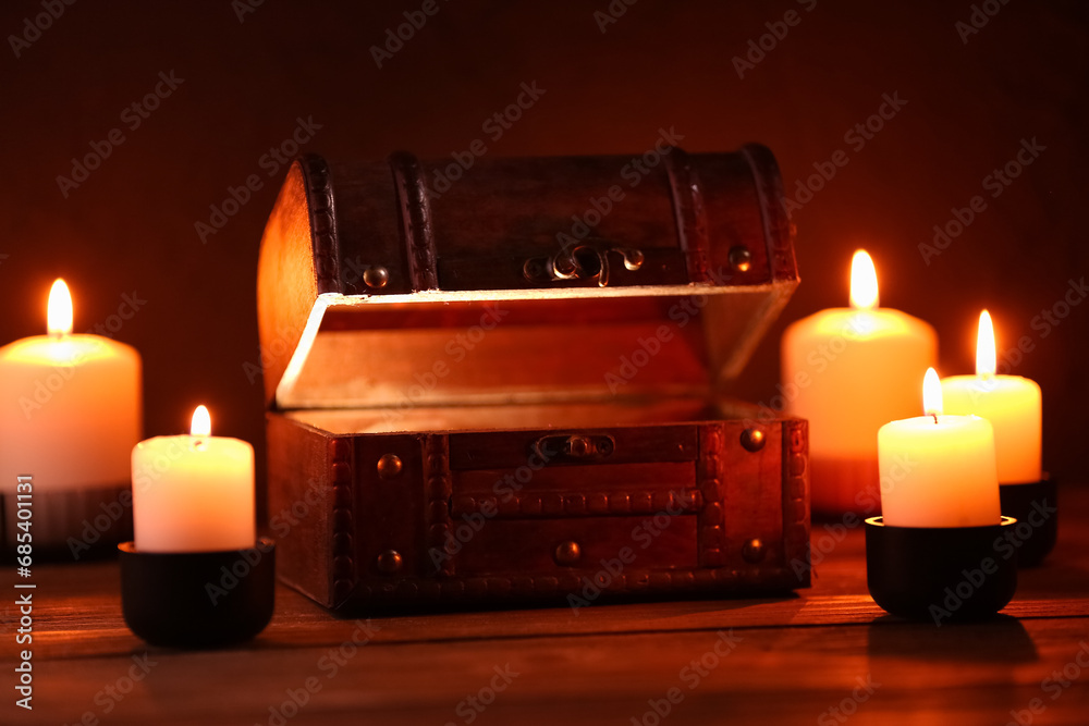Decorative box with burning candles on dark background