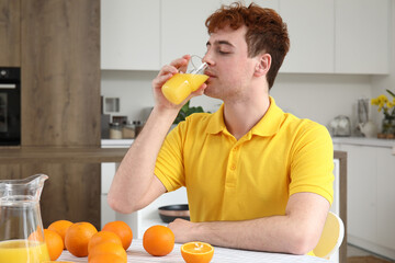 Sticker - Young man drinking orange juice in kitchen