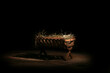 © Pixel-Shot - Manger with hay on wooden table against dark background