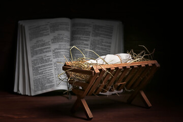 Wall Mural - Manger with baby, hay and Holy Bible on dark wooden table